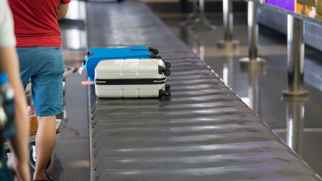Une femme grimpe sur le tapis roulant pour bagages en pensant que cela la mènerait à l'avion