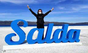 Un touriste posant devant le nom "Salda"