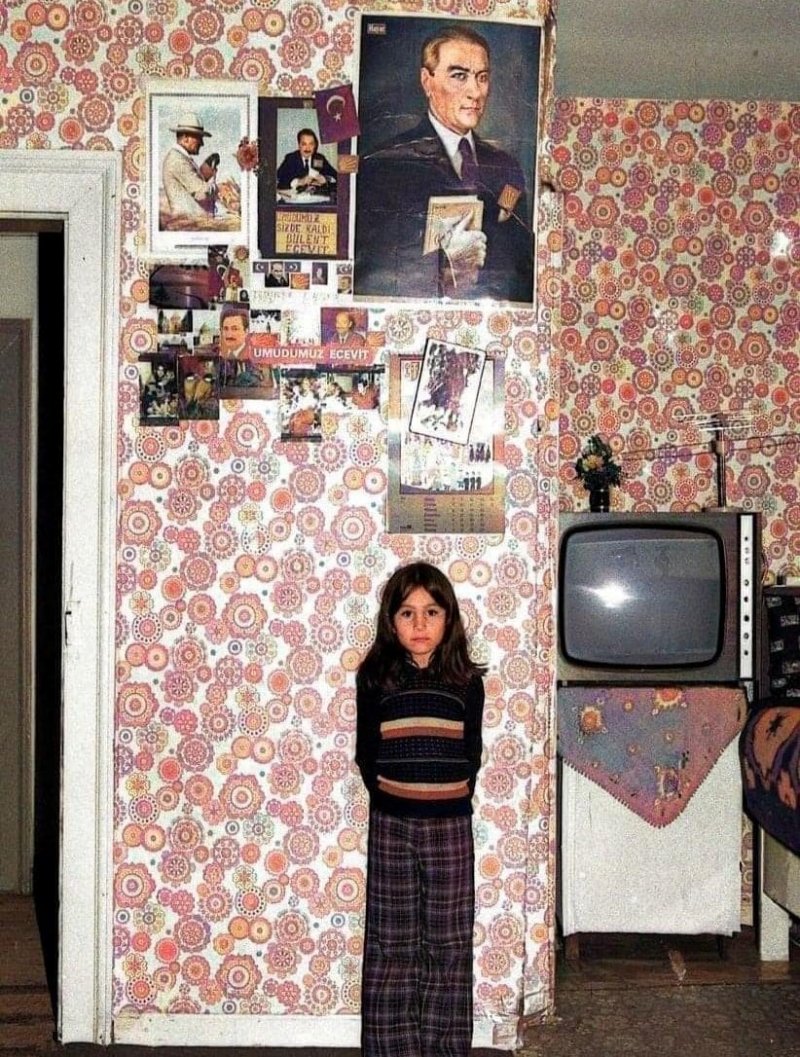 Un enfant posant devant le portrait d'Atatürk